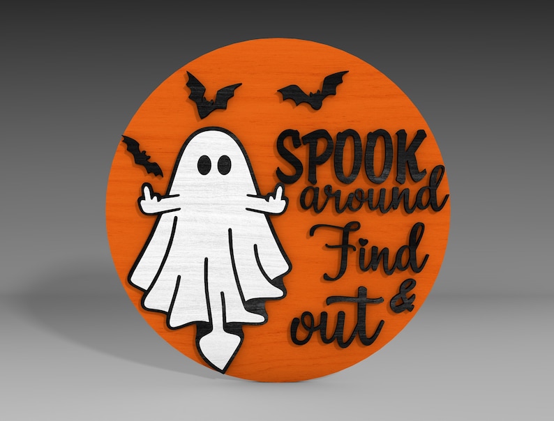 Op de afbeelding: Een rond houten bord met een oranje achtergrond en zwarte letters. Het bord toont een witte geest met zwarte ogen en een zwarte omtrek. De tekst op het bord luidt "Spook around Find out &".