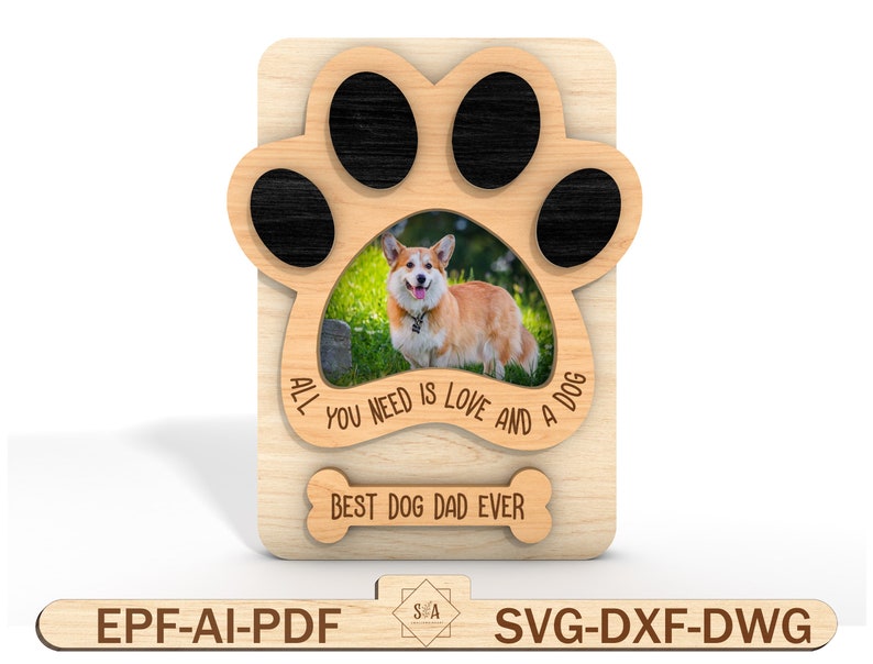 Puede incluir: Un marco de fotos de madera con forma de huella de pata con una foto de un perro en el centro. El marco tiene el texto "Todo lo que necesitas es amor y un perro" y "Mejor pap&aacute; de perro de todos los tiempos" grabado en &eacute;l.