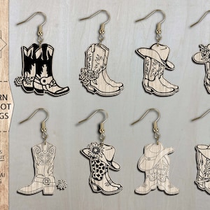 May include: Set of ten laser cut western cow boot earring designs. The earrings feature a variety of styles, including boots with flowers, hats, and spurs. The designs are all in black and white.