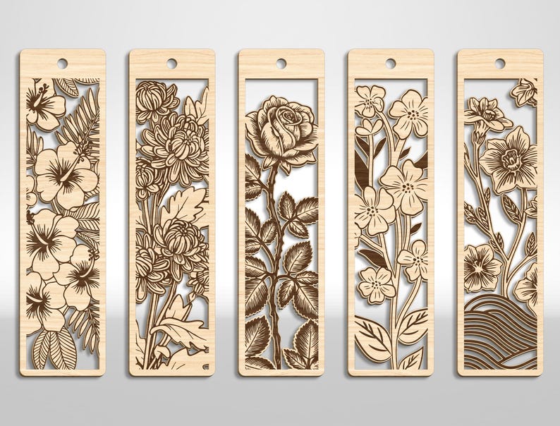 May include: Five wooden bookmarks with intricate floral designs. Each bookmark features a different flower, including hibiscus, chrysanthemums, a rose, and other blossoms. The bookmarks have a rectangular shape with a hole at the top for a tassel.