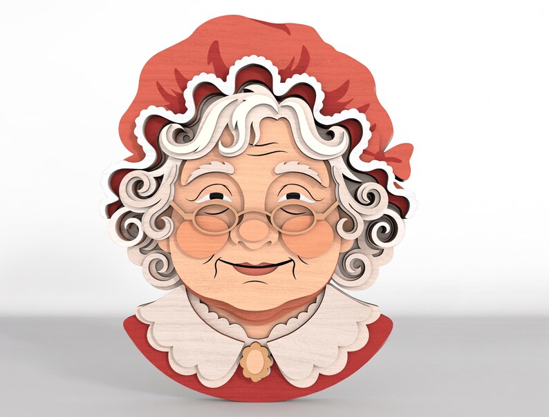 May include: A layered wooden wall art piece depicting an elderly person with white curly hair, wearing a red bonnet with a white ruffled trim, round glasses, and a white scalloped collar with a small central brooch over a red garment.