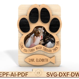 Puede incluir: Marco de fotos de madera con forma de huella de pata con una foto de un gato dentro. El marco tiene el texto "I love you furry much through thick and thin" y "Love, Elizabeth" con un icono de pez.