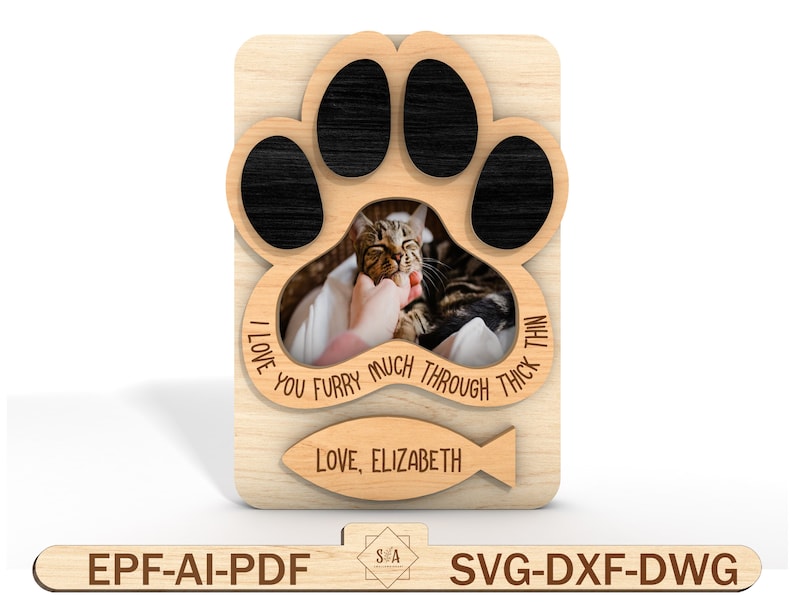 Puede incluir: Marco de fotos de madera con forma de huella de pata con una foto de un gato dentro. El marco tiene el texto "I love you furry much through thick and thin" y "Love, Elizabeth" con un icono de pez.
