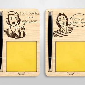 May include: Two wooden notepads with a pen holder and a sticky note pad. The left notepad has the text "Sticky thoughts for a slippery brain." The right notepad has the text "Don't forget to forget again."