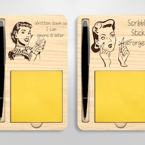 May include: A wooden desk organizer with a pen holder and a sticky note pad. The organizer features a retro-style illustration of a woman with the text "Written down so I can ignore it later." and "Scribble. Stick. Forget."