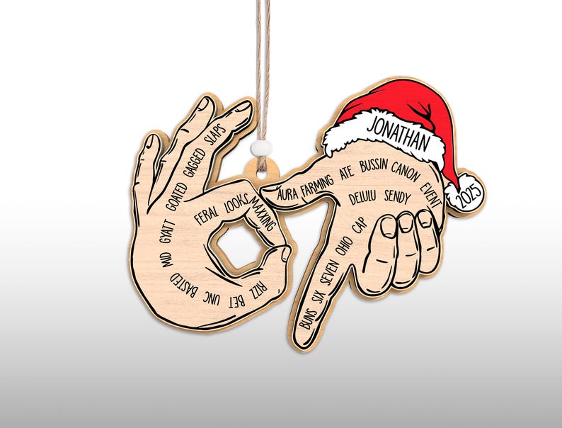 May include: Wooden Christmas ornament featuring a hand gesture with various slang terms. The ornament includes a Santa hat with the name "Jonathan" and the year "2025". It hangs from a string.