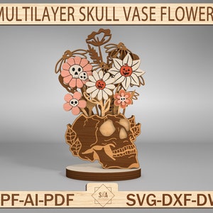 May include: A wooden skull vase with a bouquet of pink and white flowers. The flowers have small skull details and a pumpkin face. The vase is a multi-layered design and is labeled "MULTILAYER SKULL VASE FLOWERS".