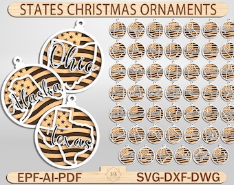 Pode incluir: Enfeites de Natal de madeira com contornos de estados dos EUA e um design de bandeira americana. Os enfeites incluem Ohio, Alasca e Texas, com o texto "STATES CHRISTMAS ORNAMENTS". Os enfeites são redondos com uma borda branca.