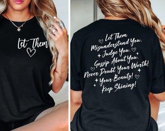 May include: Black t-shirt with white text that says "Let Them" with a heart. The back of the shirt has the text "Let Them Misunderstand You. Judge You. Gossip About You. Never Doubt Your Worth! Your Beauty! Keep Shining!"