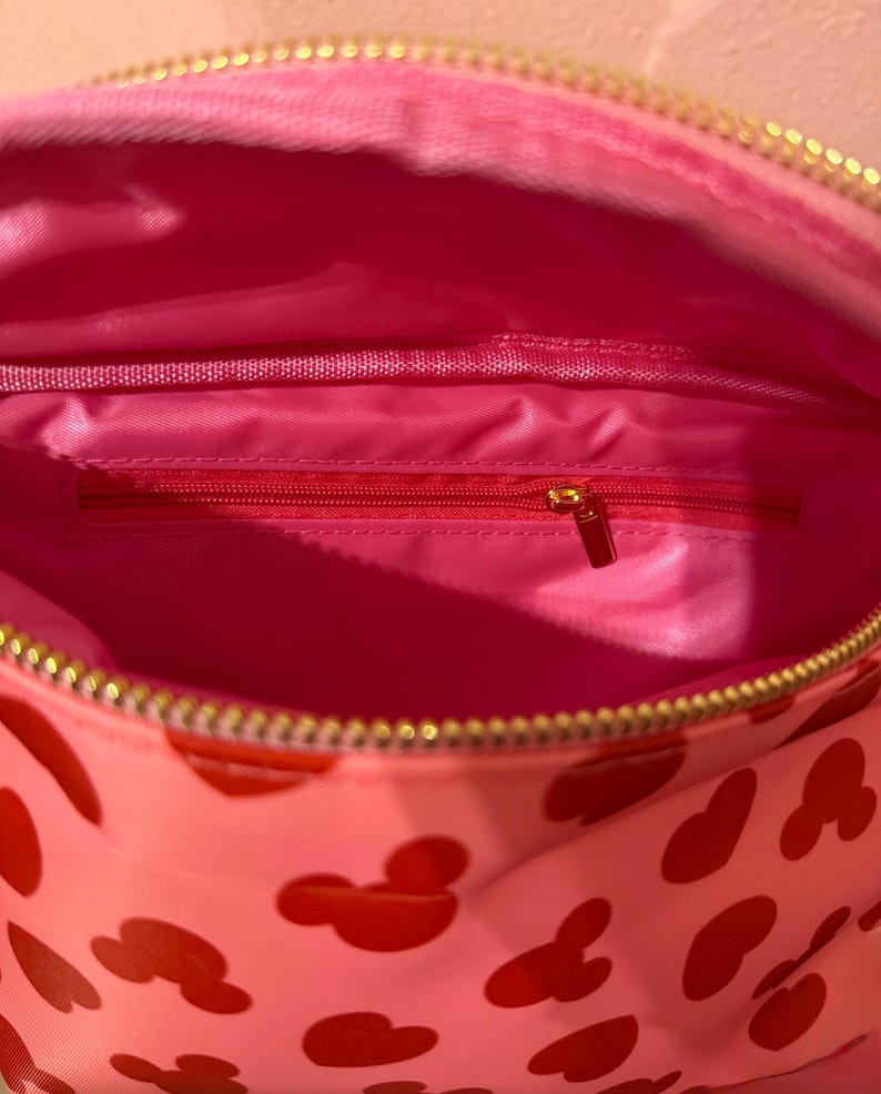 image shows the inside of the Disney pant pack with all ink in the inside and a gold hardware zipper.