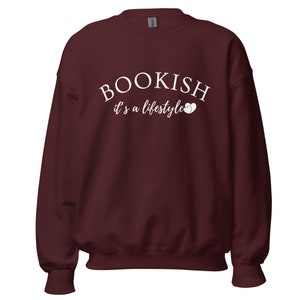 Puede incluir: Sudadera color burdeos con texto blanco que dice "BOOKISH it's a lifestyle" con dos corazones blancos.