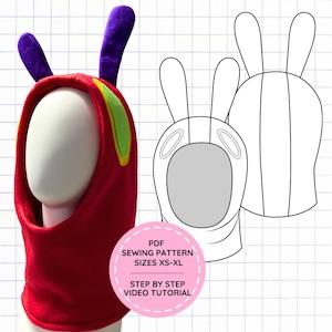 Peut inclure: Une capuche en polaire rouge avec deux antennes violettes et des accents latéraux verts, présentée à côté d'un dessin au trait noir et blanc. Une étiquette circulaire rose indique : PDF SEWING PATTERN SIZES XS-XL STEP BY STEP VIDEO TUTORIAL.