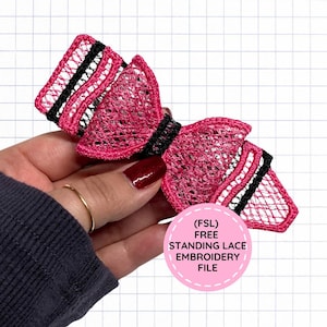 May include: A decorative bow crafted from pink and black thread in a free standing lace embroidery pattern. The bow features a lattice-like texture with alternating pink and black stripes. A circular pink label displays the text (FSL) FREE STANDING LACE EMBROIDERY FILE.