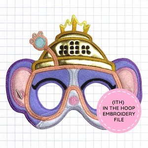 May include: A purple and light pink felt mask featuring a gold metallic crown and a small paw-shaped antenna. The mask has large eye openings and includes a pink circular graphic with the text (ITH) IN THE HOOP EMBROIDERY FILE.