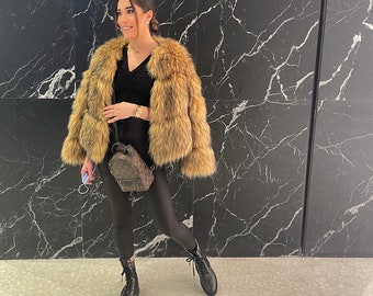 May include: A woman wearing a brown and black faux fur jacket, black leggings, and black boots. She is carrying a brown leather backpack.
