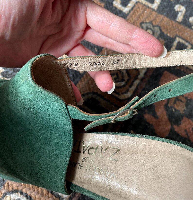 May include: Green suede heeled sandals with a buckle closure. The insole is labeled "Zapat" and the sole has the numbers "7B 2422 15".