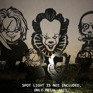 K&ouml;nnte beinhalten: F&uuml;nf schwarze Metallsilhouetten von Horrorfilmfiguren, darunter Pennywise der Clown, Chucky und Jigsaw, an einer Wand montiert. Der Text "SPOT LIGHT IS NOT INCLUDED, ONLY METAL ARTS." ist unter den Silhouetten gedruckt.