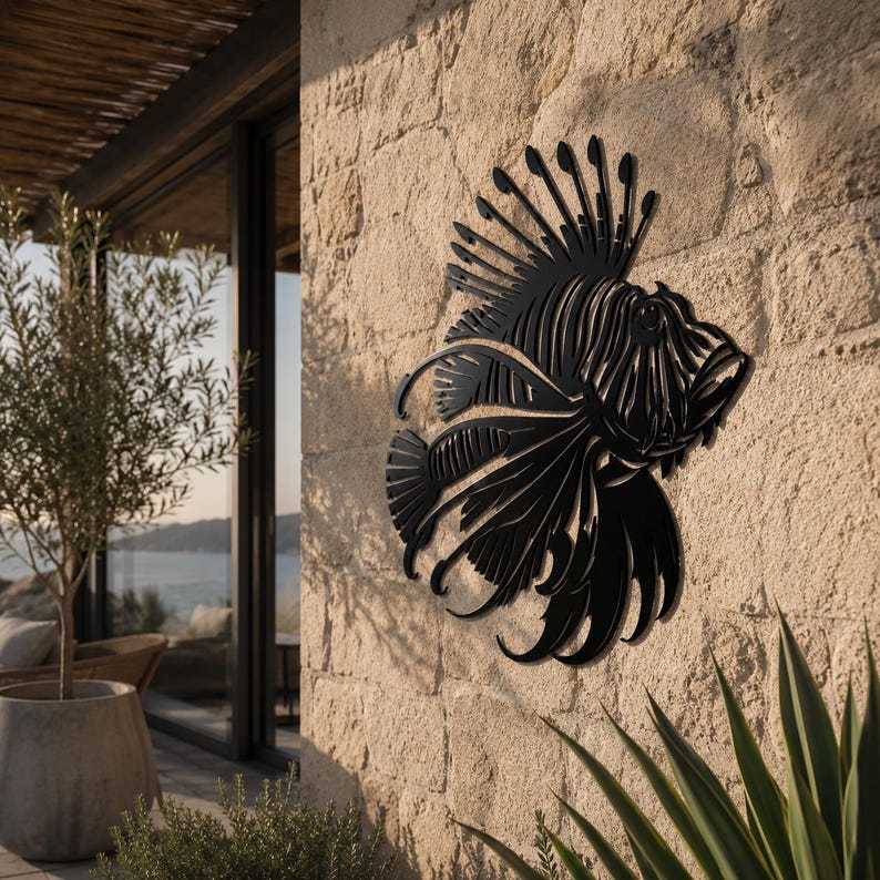 Puede incluir: Una pieza de arte mural de metal negro con forma de pez le&oacute;n, que presenta intrincados detalles recortados que definen las aletas espinosas, la cola fluida y la estructura corporal distintiva del pez, montada sobre una pared de piedra.