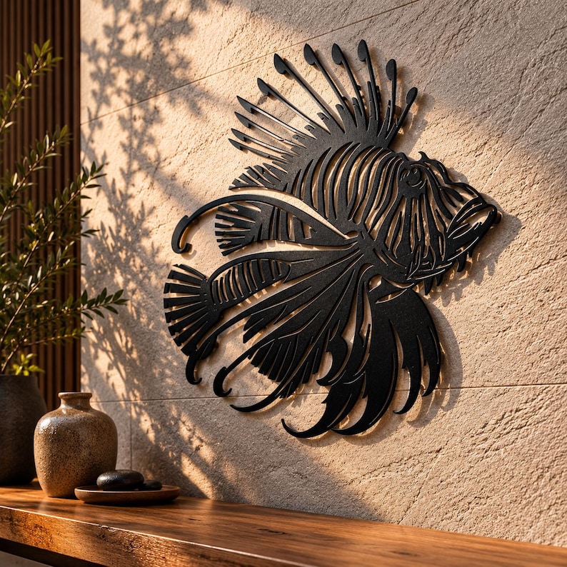 Puede incluir: Una pieza de arte mural de metal negro con forma de pez le&oacute;n, que presenta intrincados detalles recortados que definen las aletas, las espinas y la estructura corporal del pez. La silueta es plana y oscura, contrastando con la pared texturizada.