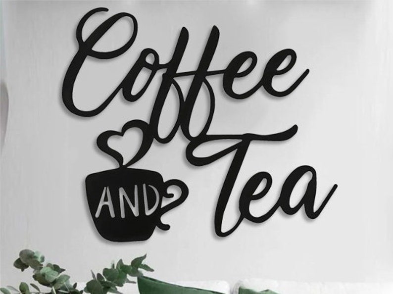Puede incluir: Arte de pared de metal negro con las palabras "Coffee and Tea" en una fuente cursiva. La palabra "Coffee" est&aacute; encima de "Tea". Una taza con un dise&ntilde;o de vapor en forma de coraz&oacute;n aparece con la palabra "AND" en el medio.