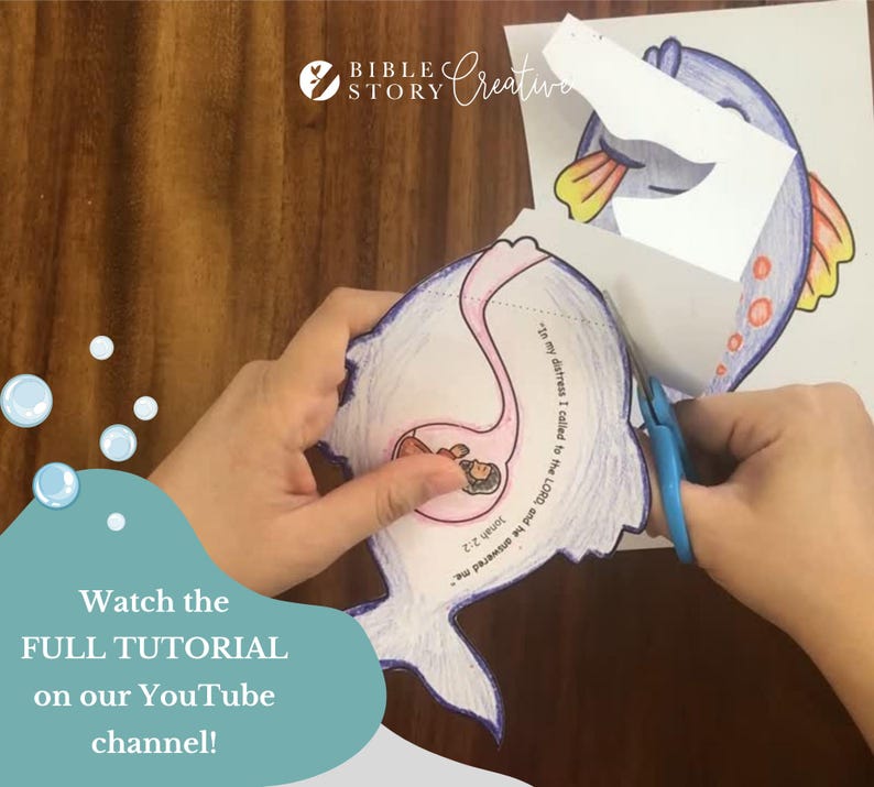 May include: A person is cutting out a paper fish with scissors. The fish is part of a Bible Story Creative craft project. The image includes text that says "Watch the FULL TUTORIAL on our YouTube channel!"