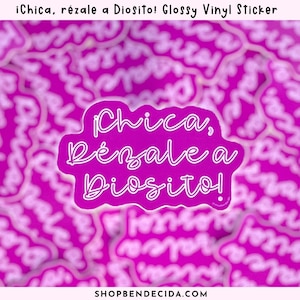 May include: A glossy vinyl sticker with the text "iChica, rézale a Diosito!" in white lettering on a bright pink background. The sticker is surrounded by other stickers with the same design.