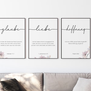 Könnte beinhalten: Drei gerahmte Drucke mit den Wörtern "glaube", "liebe" und "hoffnung" in kursivschrift. Jeder Druck zeigt ein Aquarell-Blumendesign und einen Bibelvers.