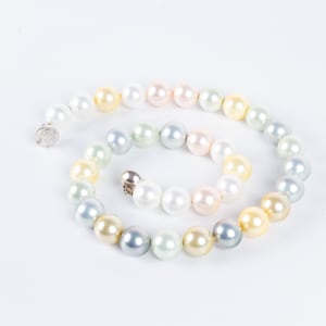 May include: A multi-colored pearl necklace with a silver clasp. The pearls are in shades of white, cream, light blue, and light yellow.