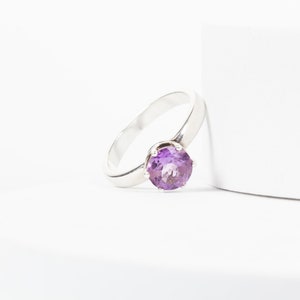 K&ouml;nnte beinhalten: Ein silberner Ring mit einem violetten Amethyst-Edelstein.