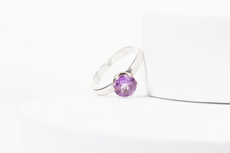 K&ouml;nnte beinhalten: Ein silberner Ring mit einem violetten Amethyst-Edelstein.
