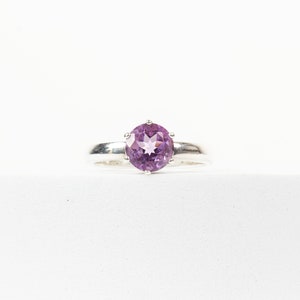 K&ouml;nnte beinhalten: Ein silberner Ring mit einem violetten Amethyst-Edelstein.