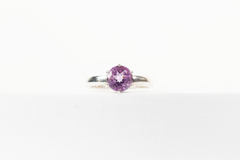 K&ouml;nnte beinhalten: Ein silberner Ring mit einem violetten Amethyst-Edelstein.