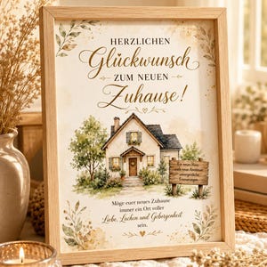 May include: A framed print in a light wood frame featuring a watercolor illustration of a house with the German text: Herzlichen Glückwunsch zum neuen Zuhause! Ein neues Haus, viele neue Abenteuer, unvergessliche Erinnerungen. Möge euer neues Zuhause immer ein Ort voller Liebe, Lachen und Geborgenheit sein.