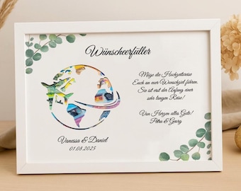 May include: White framed print with a colorful world map design, airplanes, and text. The print includes the names "Vanessa & Daniel" and the date "01.08.2025". Decorative eucalyptus leaves frame the print.