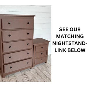 May include: A brown wooden chest of drawers with five drawers and black knobs. The chest of drawers is on a white wood floor. See our matching bedside table - link below.