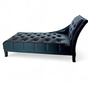May include: A black chaise lounge with a tufted seat and backrest. The chaise lounge has a curved back and armrest, and is supported by four legs. The seat and back are button-tufted, adding a touch of elegance to the furniture.