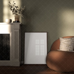 Puede incluir: Un sillón marrón con un cojín estampado se encuentra frente a una chimenea blanca y un cuadro enmarcado en una pared verde.