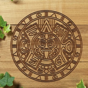Op de afbeelding: Een ronde houten carving met een ingewikkeld ontwerp van een gezicht met een grote tong en een omringende cirkel van cijfers en symbolen.