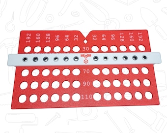 May include: A red tool with multiple holes and measurements. The tool has a white bar with additional holes and numbers. Numbers include 30, 32, 64, 70, 90, 96, 110, 128, 160, and 192. The tool is designed for measuring and marking.
