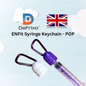 Pu&ograve; includere: Due portachiavi a forma di siringa con dettagli viola e bianchi. Uno ha un corpo siringa viola e un tappo bianco, l'altro un tappo viola. Il testo "ENFit Syringe Keychain - POP" &egrave; visibile.
