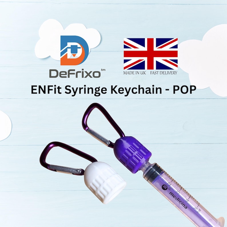 Pu&ograve; includere: Due portachiavi a forma di siringa con dettagli viola e bianchi. Uno ha un corpo siringa viola e un tappo bianco, l'altro un tappo viola. Il testo "ENFit Syringe Keychain - POP" &egrave; visibile.