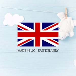 Pu&ograve; includere: Una bandiera Union Jack con strisce rosse e bianche e sfondo blu, con la scritta "MADE IN UK". Un orsacchiotto di peluche bianco &egrave; appeso a un filo. Una nuvola bianca si trova nell'angolo in alto a sinistra.