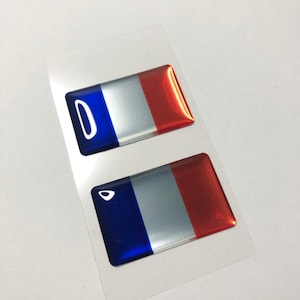 Peut inclure: Deux petits autocollants en résine 3D du drapeau français. Les autocollants sont bleus, blancs et rouges.