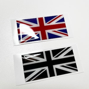 May include: Two Union Jack flags, one with red, white, and blue colors and the other with black and white colors. Both flags are on white backgrounds.