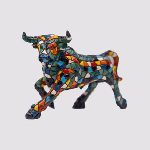 May include: A colorful mosaic bull sculpture with a dynamic pose. The bull is covered in a mosaic of various colors, including blue, green, red, yellow, and orange. The sculpture has horns and is on a white background.