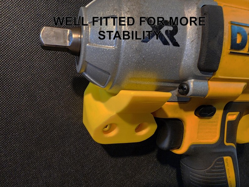 May include: A yellow and black impact wrench with a yellow plastic holder. The holder has two holes for mounting. The wrench has the text "WELL FITTED FOR MORE STABILITY XR" printed on it.