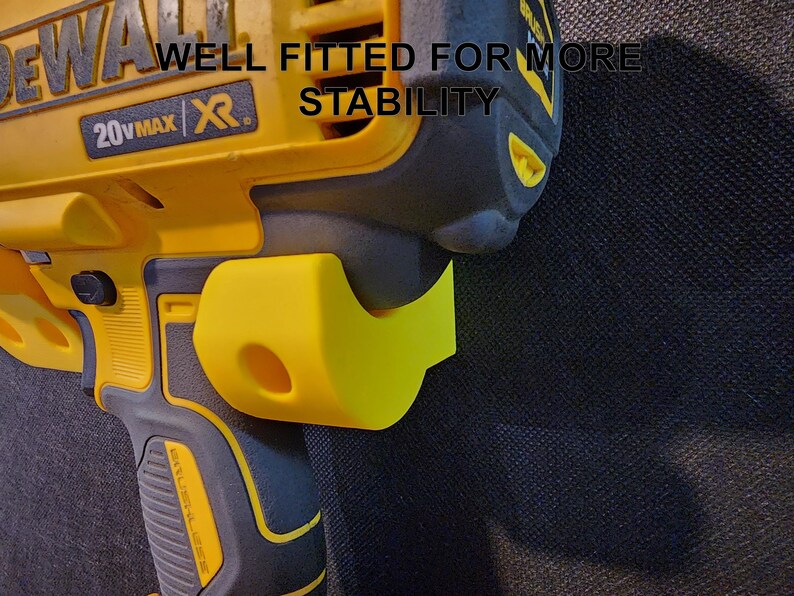 May include: A yellow and black DeWalt 20V MAX XR drill with a black and yellow plastic side handle. The text "WELL FITTED FOR MORE STABILITY" is printed on the drill.