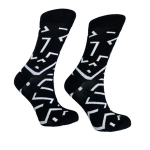 Könnte beinhalten: Ein Paar schwarze Socken mit einem weißen geometrischen Muster. Die Socken sind aus einem weichen, bequemen Material gefertigt und perfekt für den Alltag.