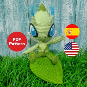 Może przedstawiać: Zielona pluszowa zabawka amigurumi postaci Pokemon siedzącej na zielonym liściu zrobionym na szydełku. Zabawka ma niebieskie oczy i czułki. Tło to drewniana powierzchnia z zielonym materiałem przypominającym trawę.