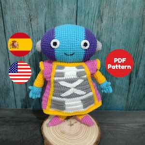 Peut inclure: Patron d'amigurumi au crochet pour un personnage bleu et violet avec une robe jaune et rose. Le patron est disponible en format PDF. L'image comprend les drapeaux de l'Espagne et des États-Unis.